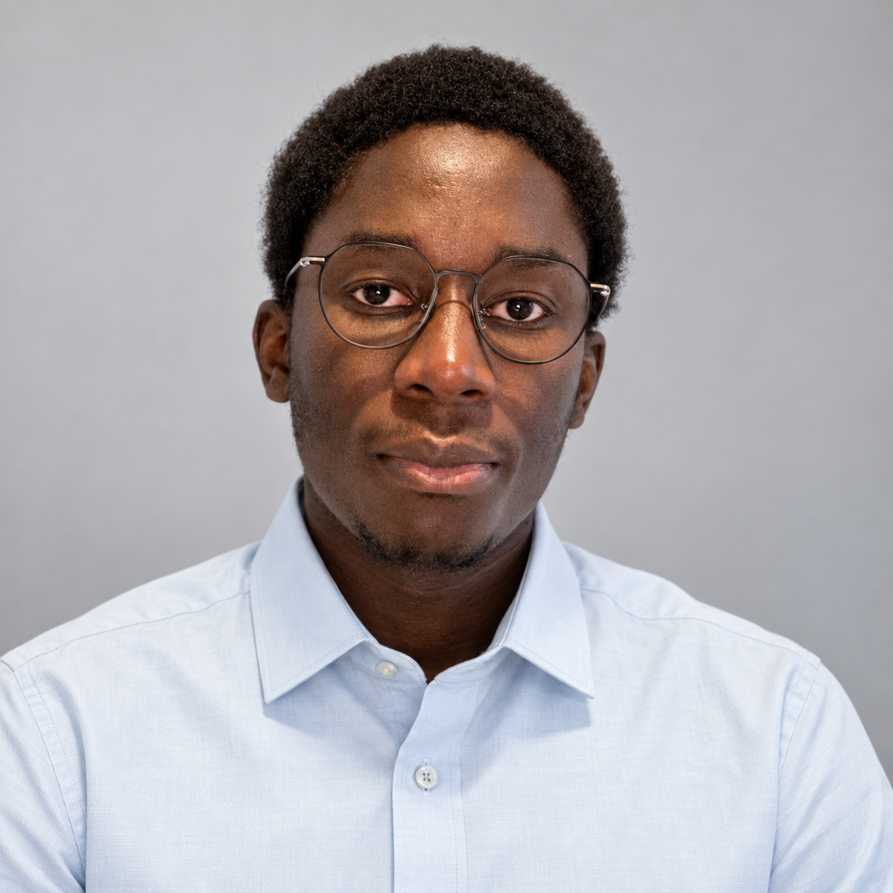 Portrait d’Abdoulaye portant une chemise bleu clair et des lunettes